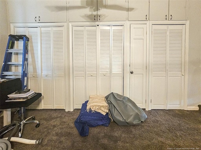 bedroom featuring two closets and dark carpet