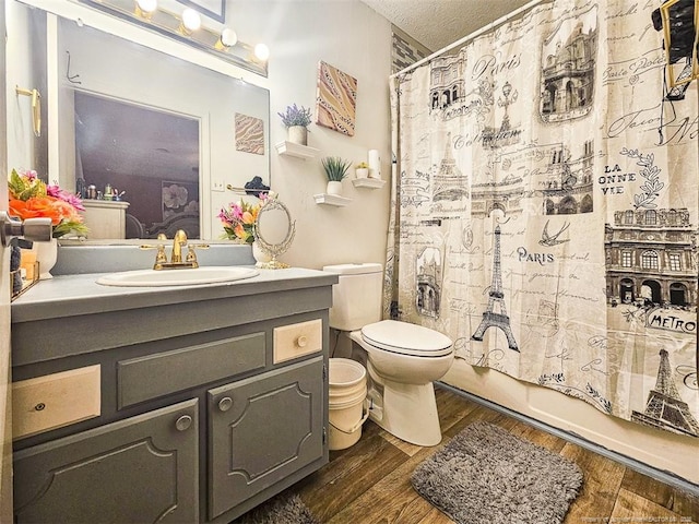 bathroom with shower / tub combo with curtain, vanity, toilet, and wood finished floors