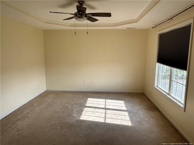 carpeted empty room with a raised ceiling, baseboards, a ceiling fan, and visible vents