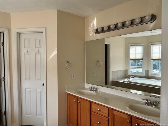 full bathroom with double vanity, a garden tub, and a sink