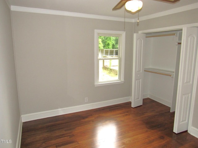 unfurnished bedroom featuring ornamental molding, baseboards, a closet, and dark wood finished floors