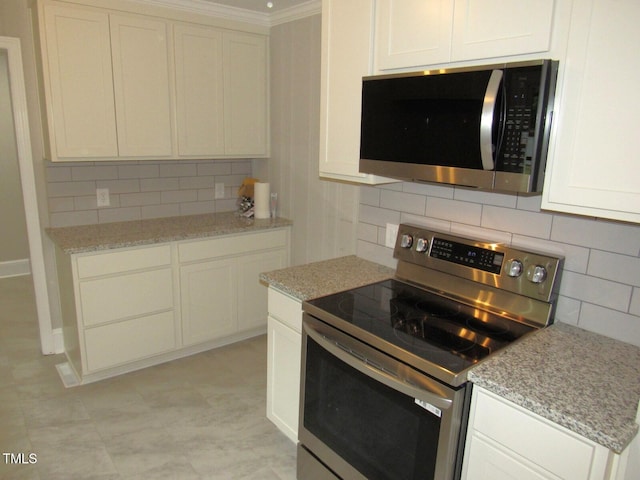 kitchen featuring crown molding, tasteful backsplash, light stone counters, and appliances with stainless steel finishes