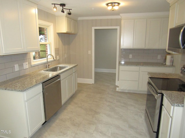 kitchen featuring crown molding, decorative backsplash, appliances with stainless steel finishes, and a sink