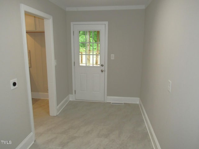 entryway with ornamental molding, baseboards, and visible vents