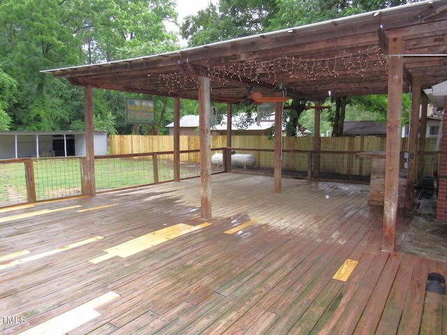 wooden terrace with a fenced backyard and an outbuilding