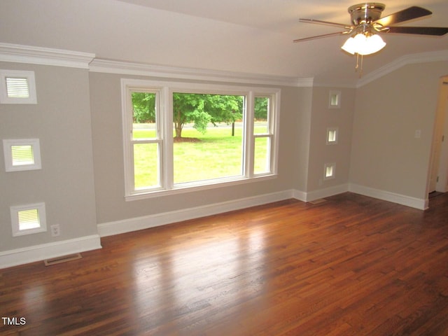 unfurnished room featuring a ceiling fan, dark wood finished floors, visible vents, baseboards, and ornamental molding