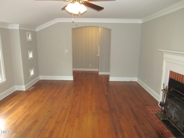 unfurnished living room featuring wood finished floors, a ceiling fan, a fireplace with flush hearth, crown molding, and baseboards