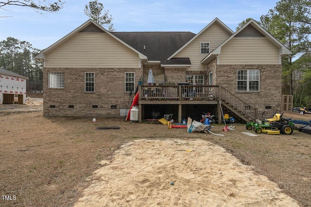 rear view of property featuring stairway, a wooden deck, brick siding, and crawl space