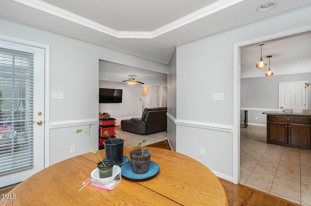 dining area with tile patterned floors, baseboards, ceiling fan, and crown molding