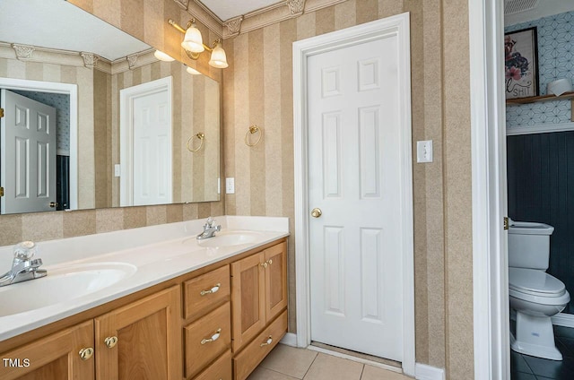 full bathroom with tile patterned floors, wallpapered walls, toilet, and a sink
