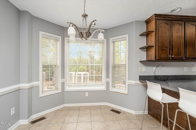 unfurnished dining area featuring a chandelier, plenty of natural light, and visible vents