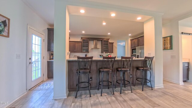 2912 Epps Clark Rd, Siler City, NC 27344 - kitchen with wall chimney range hood, a peninsula, light wood finished floors, plenty of natural light, and recessed lighting
