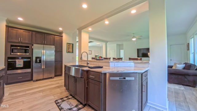 2912 Epps Clark Rd, Siler City, NC 27344 - kitchen featuring stainless steel appliances, open floor plan, a sink, dark brown cabinetry, and light wood finished floors