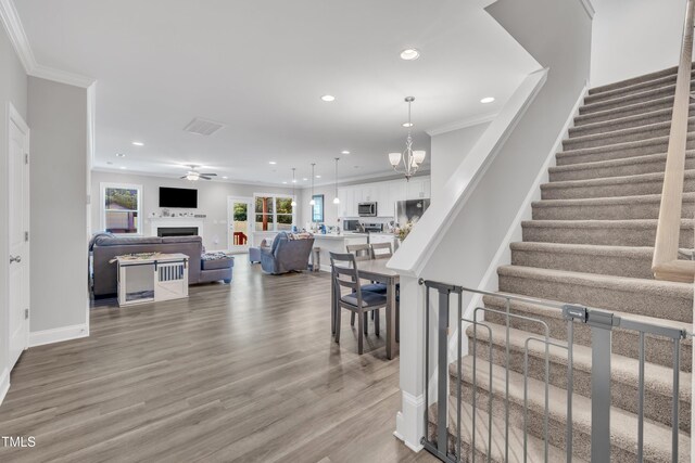 9 Little Sunshine Brk, Smithfield, NC 27577 - stairs with a fireplace, crown molding, wood finished floors, recessed lighting, and baseboards