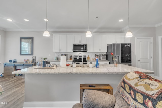 9 Little Sunshine Brk, Smithfield, NC 27577 - kitchen featuring appliances with stainless steel finishes, white cabinets, a kitchen island with sink, crown molding, and a breakfast bar area