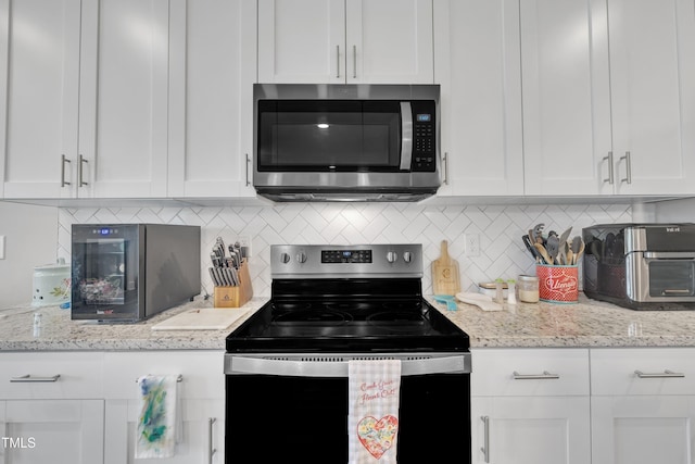 9 Little Sunshine Brk, Smithfield, NC 27577 - kitchen with stainless steel microwave, black range with electric cooktop, white cabinets, and decorative backsplash