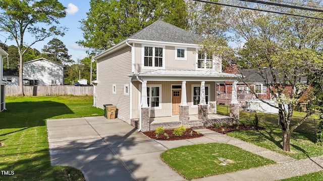 view of front of property featuring fence, a front lawn, a porch, roof with shingles, and a standing seam roof