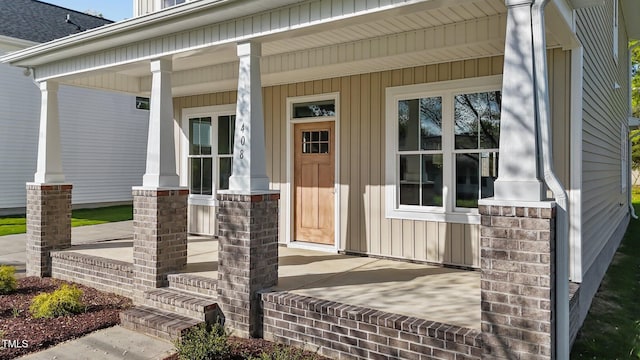 view of exterior entry featuring covered porch
