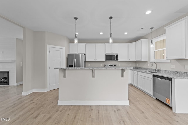 kitchen featuring a sink, stainless steel appliances, baseboards, and white cabinets