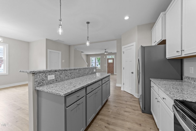 kitchen with light wood-type flooring, gray cabinetry, baseboards, and a center island