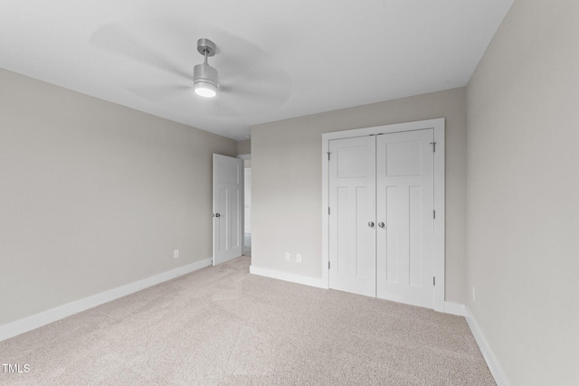 unfurnished bedroom featuring ceiling fan, carpet, a closet, and baseboards