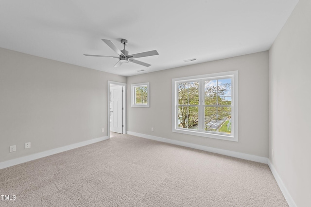 carpeted empty room featuring a ceiling fan, baseboards, and visible vents