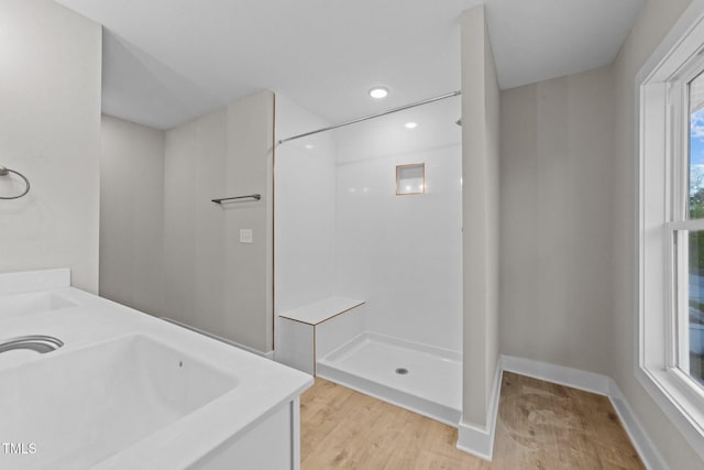 bathroom with recessed lighting, baseboards, a sink, wood finished floors, and a shower