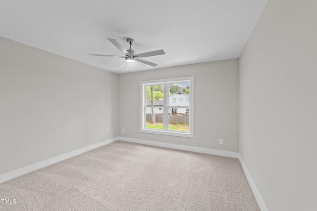 spare room featuring baseboards, a ceiling fan, and carpet