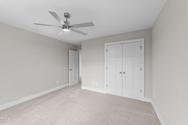 unfurnished bedroom with baseboards, light carpet, a closet, and ceiling fan