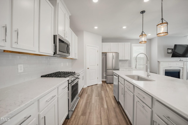 712 Emmer St, Rolesville, NC 27571 - kitchen featuring appliances with stainless steel finishes, a sink, light wood finished floors, recessed lighting, and backsplash