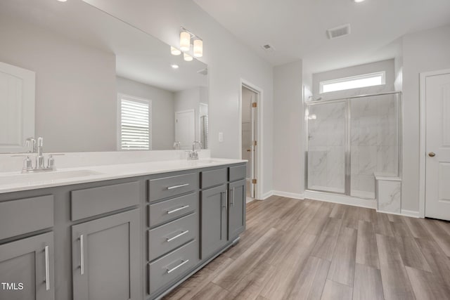 712 Emmer St, Rolesville, NC 27571 - bathroom featuring plenty of natural light, a marble finish shower, double vanity, and wood finished floors
