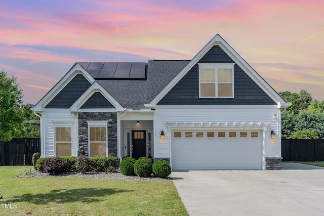 craftsman-style home with stone siding, concrete driveway, and roof mounted solar panels