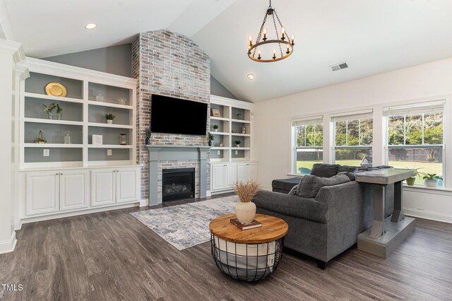 living area featuring lofted ceiling, dark wood-type flooring, a chandelier, and plenty of natural light
