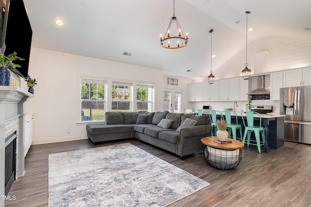 living area featuring a chandelier, wood finished floors, a fireplace, recessed lighting, and baseboards