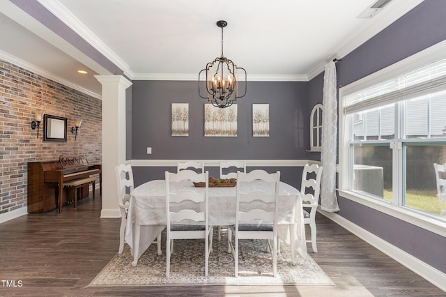 dining space featuring a chandelier, baseboards, wood finished floors, brick wall, and crown molding