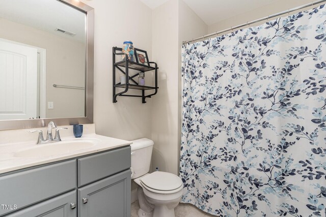 bathroom featuring toilet, vanity, and a shower with curtain