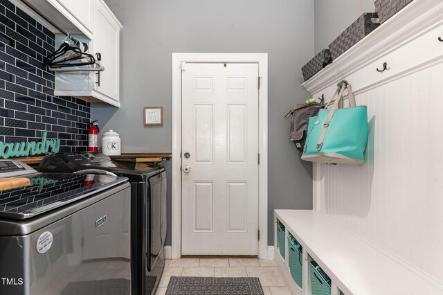 washroom with washer and dryer, cabinet space, and light tile patterned flooring