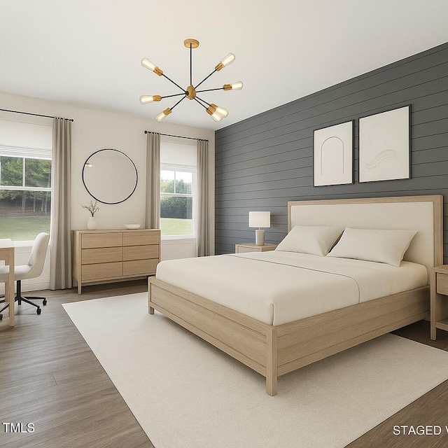 bedroom featuring a chandelier, multiple windows, and wood finished floors