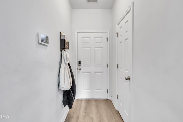 doorway with light wood-style floors and baseboards