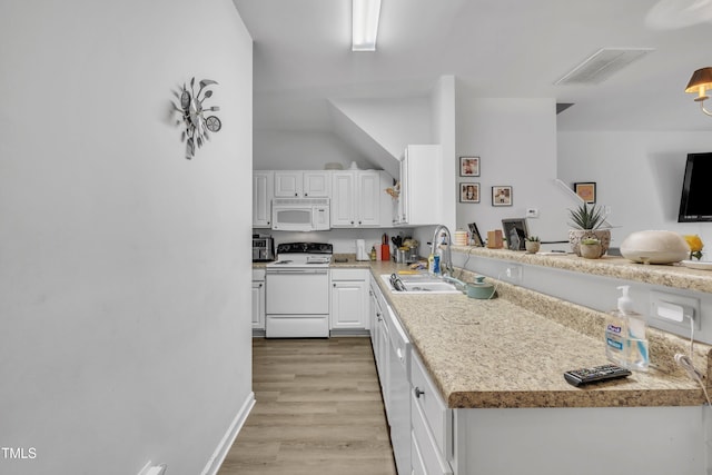 kitchen with a sink, white appliances, white cabinets, light countertops, and vaulted ceiling