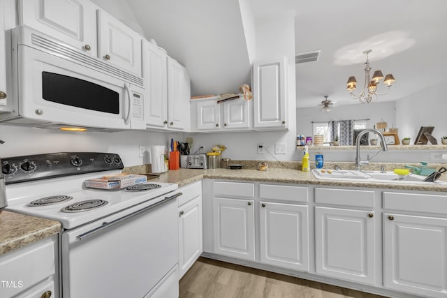 kitchen with white appliances, a chandelier, white cabinets, and light countertops