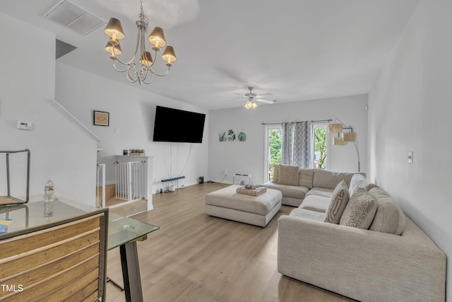 living area featuring a ceiling fan, light wood-style floors, and a chandelier