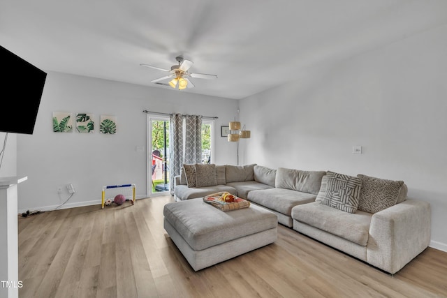 living area featuring ceiling fan, light wood-style floors, and baseboards