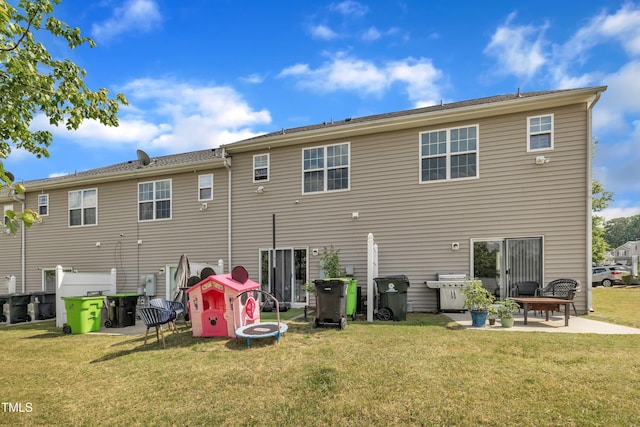 rear view of house featuring a patio and a yard