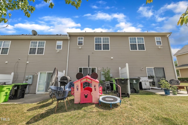rear view of property with a lawn and a patio