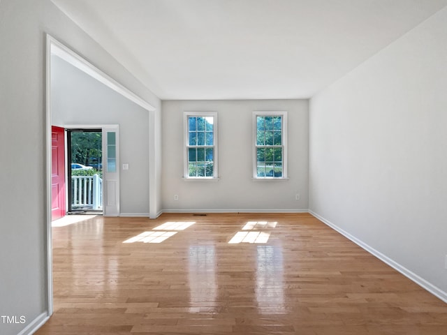 unfurnished room with baseboards and light wood-style floors