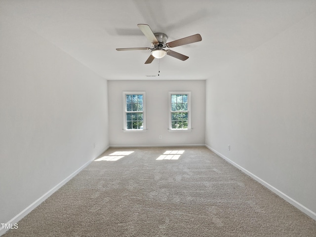 empty room with carpet flooring, baseboards, and ceiling fan