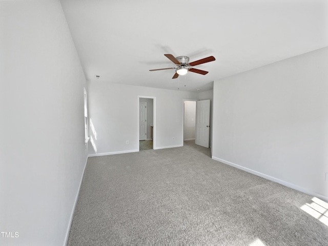 carpeted empty room with baseboards and a ceiling fan
