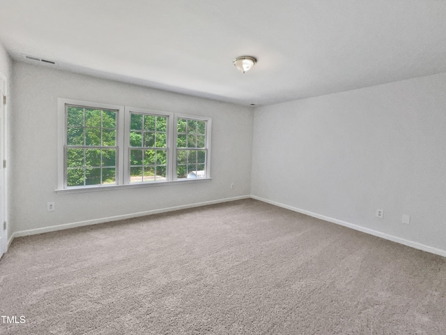 spare room featuring carpet floors, baseboards, and visible vents