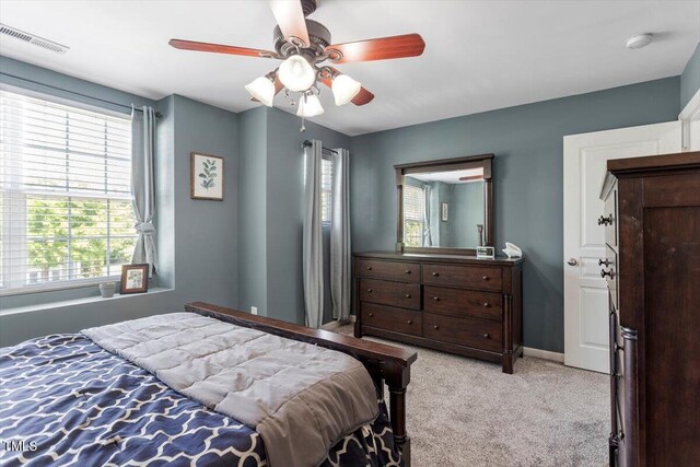 bedroom with light colored carpet, a ceiling fan, and baseboards